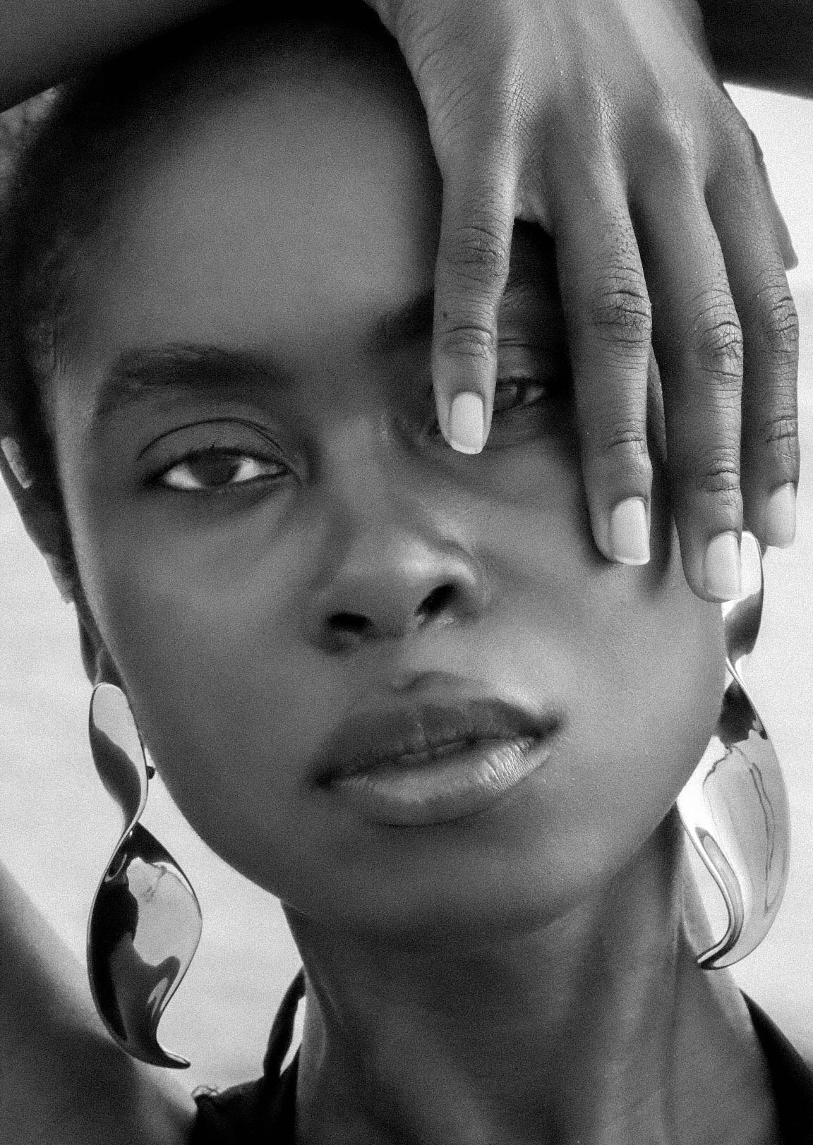 Black-and-white close beauty portrait with one hand framing the eye