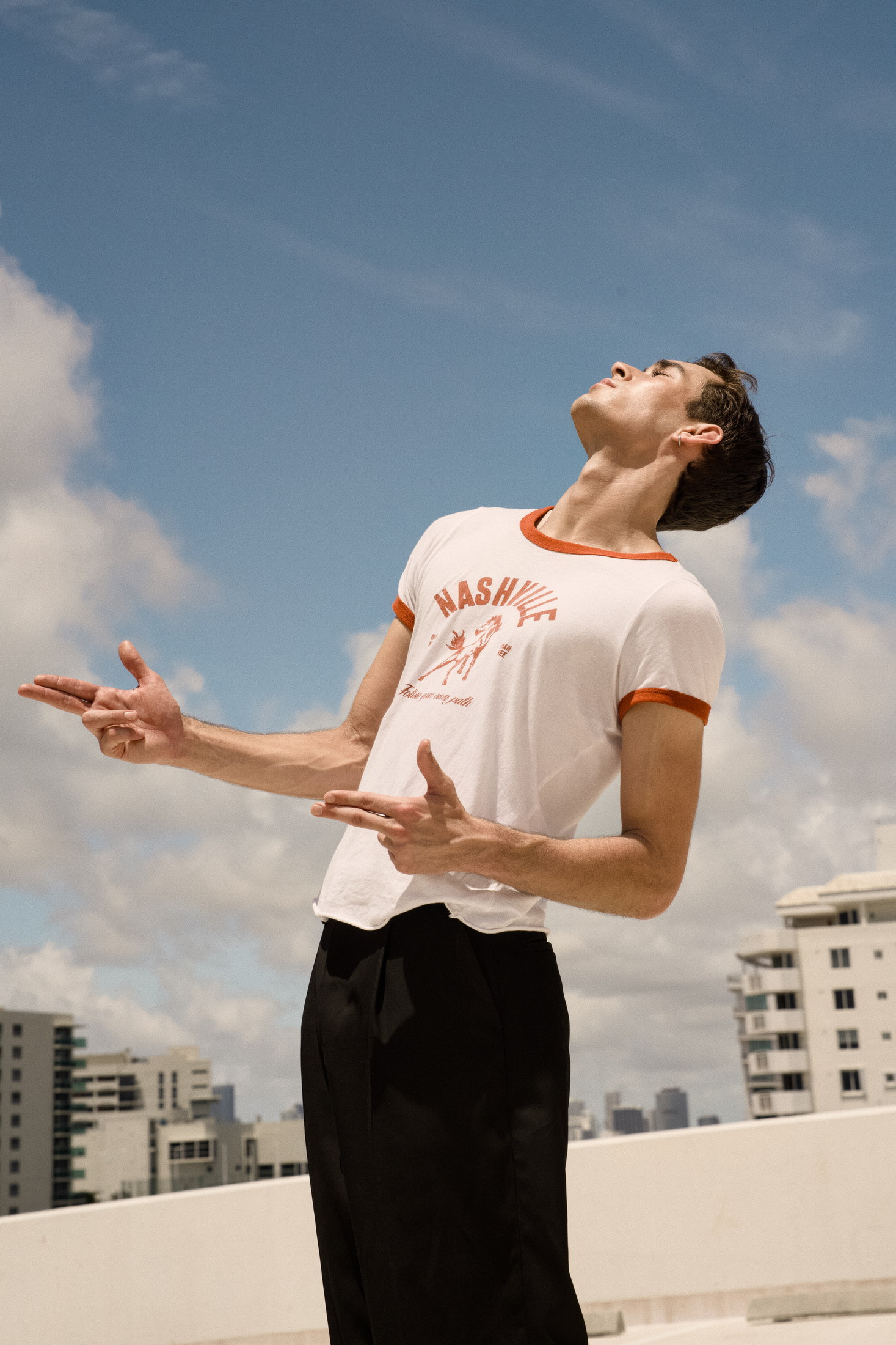 Rooftop menswear portrait looking upward into a blue sky