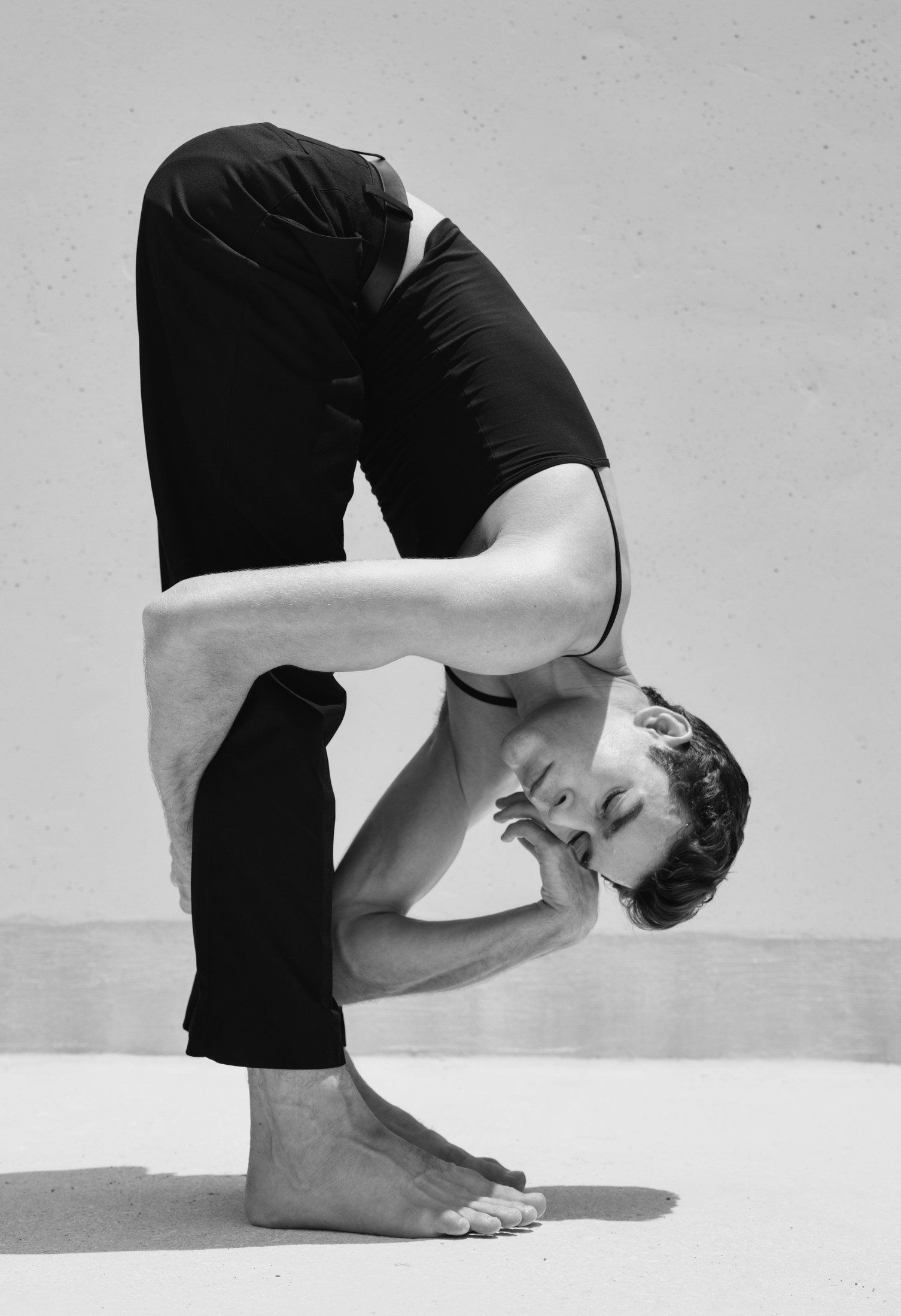 Black-and-white folded movement portrait against a minimal wall