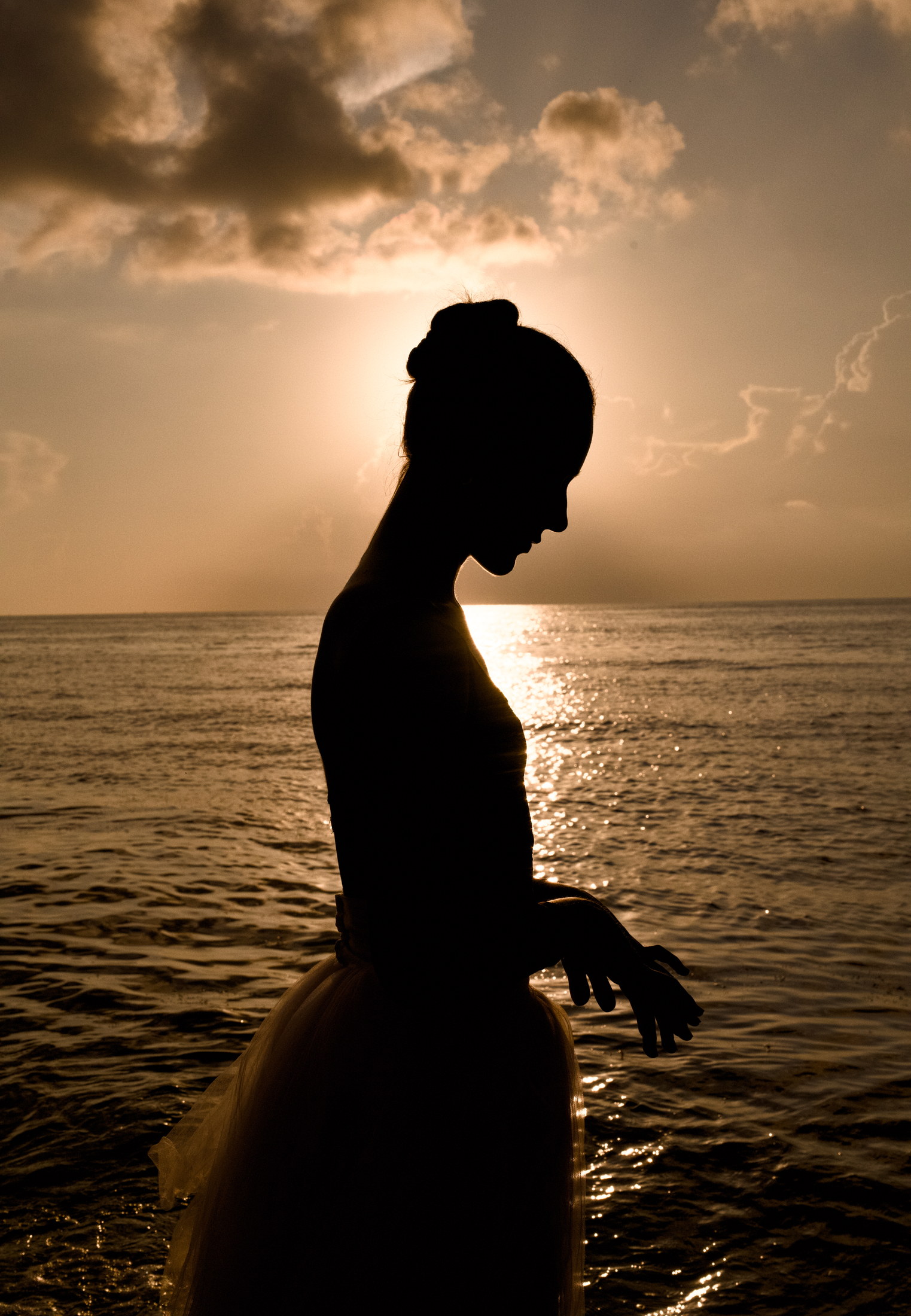 Silhouetted ballet profile at a dramatic ocean sunset