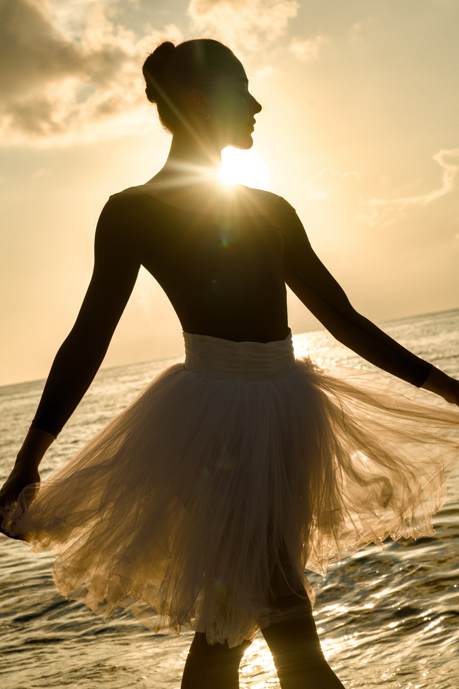 Backlit ballet portrait in a white tutu at the shoreline