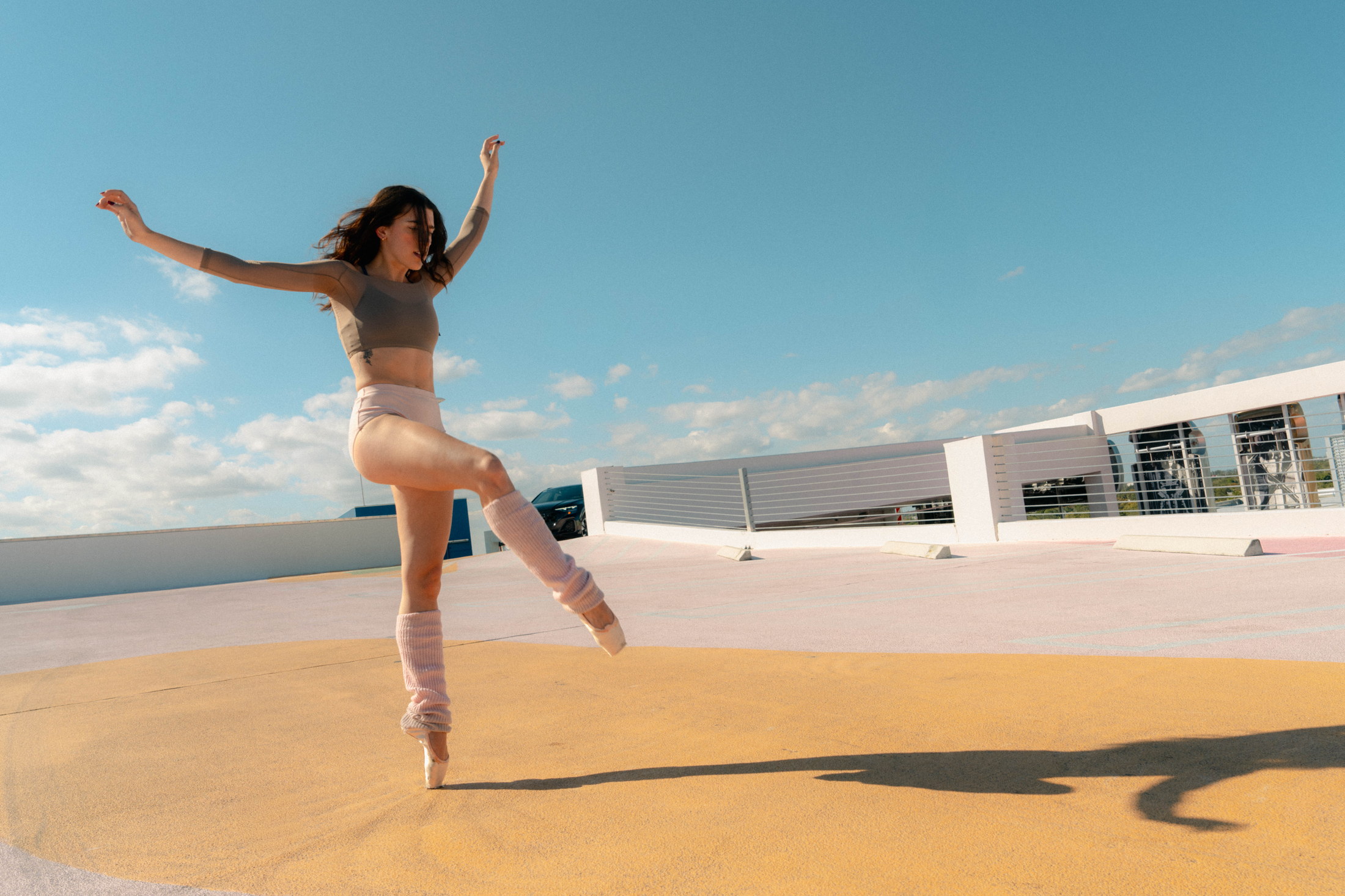 Wide rooftop movement portrait beneath a clear blue sky